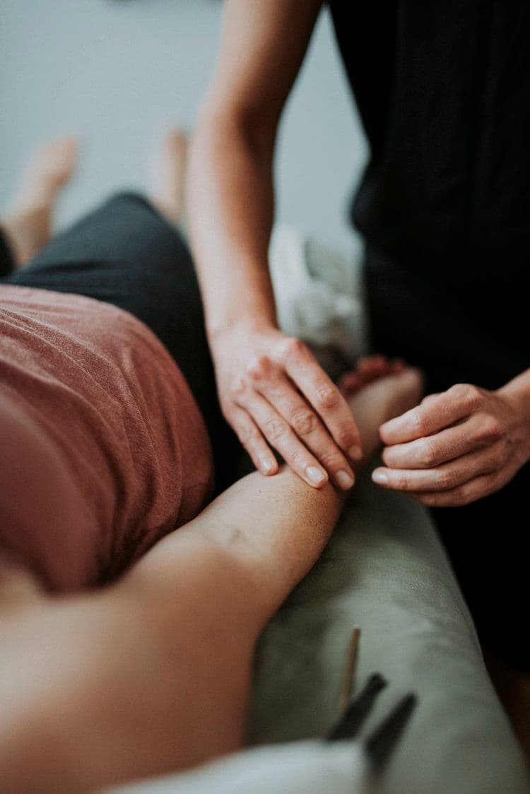 Terapeuta a avaliar o braço de uma paciente durante uma sessão de Medicina Tradicional Chinesa